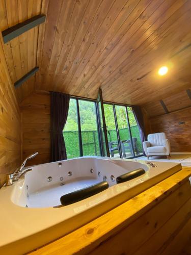 a large bath tub in a room with wooden ceilings at Yıldız Otel Dağ Evi in Çamlıhemşin