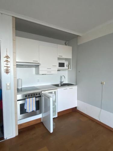 a kitchen with white cabinets and a sink at Fewo GüNi Ostseeblick Wendtorf Marina Strand in Wendtorf