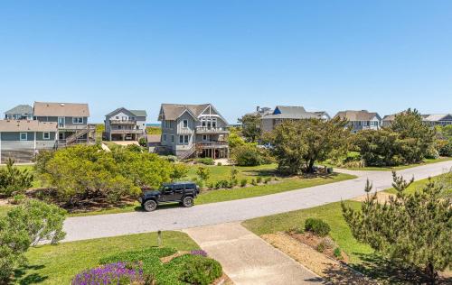 a truck driving down a road in a residential neighborhood at Duck Diamond - Sanderling, Ocean View, 95 Yds to Beach, Hot Tub, Sauna, Community Pool in Duck
