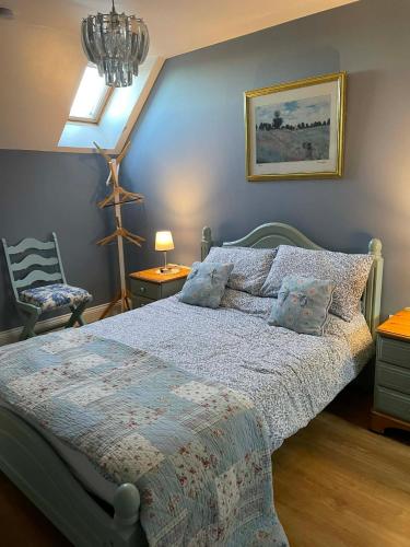 a bedroom with a bed and a lamp and a chair at The Old Farm Gite in Amfreville