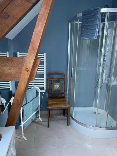a bathroom with a shower and a wooden chair at The Old Farm Gite in Amfreville