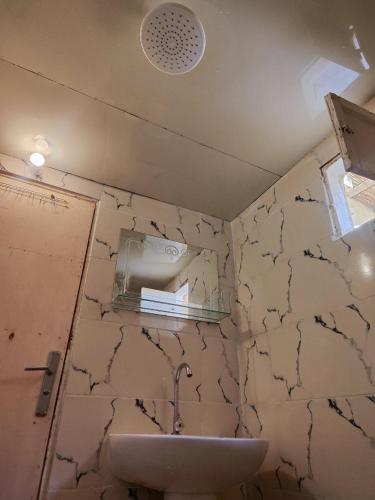 a bathroom with a sink and a mirror at Historical Mayor's House in Qasr Al Farafirah