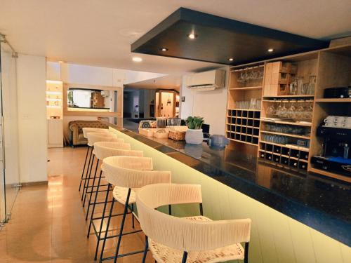 a bar with a row of stools in a room at Ambar Hotel Boutique Cali in Cali