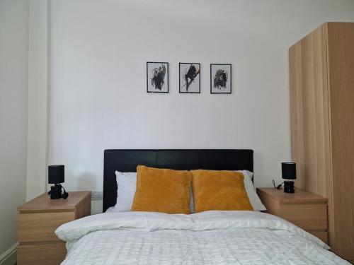 a bedroom with a bed with three pictures on the wall at The Cossy Nook in Bolton