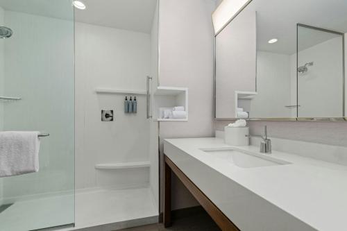 a white bathroom with two sinks and a shower at Courtyard by Marriott Oxford in Oxford
