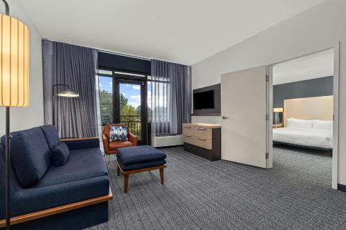 a hotel room with a couch and a bed at Courtyard by Marriott Oxford in Oxford