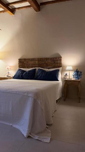 a bedroom with a bed with a white blanket and two lamps at Porto 24 in Portoferraio