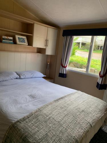 a bedroom with a large bed and a window at Park Home in Watchet