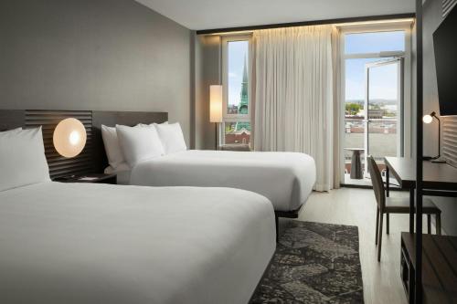 a hotel room with two beds and a window at AC Hotel by Marriott Burlington in Burlington