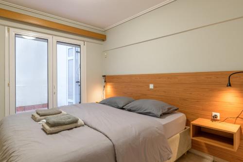 a bedroom with a large bed with a wooden headboard at Two steps from Acropolis in Athens
