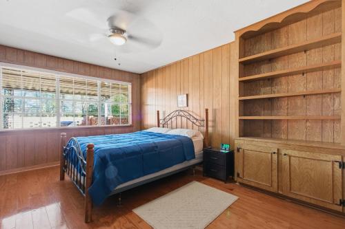 a bedroom with wooden walls and a bed and a window at Rustic Retreat 5-BR Home with Backyard Oasis in Baton Rouge