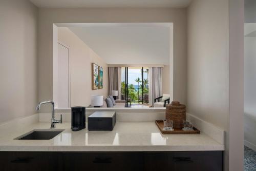 a kitchen with a sink and a living room at Waikoloa Beach Marriott Resort & Spa in Waikoloa