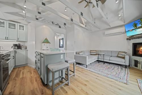 a white kitchen with a living room and a couch at Private Cottage on Annie in Coeur d'Alene