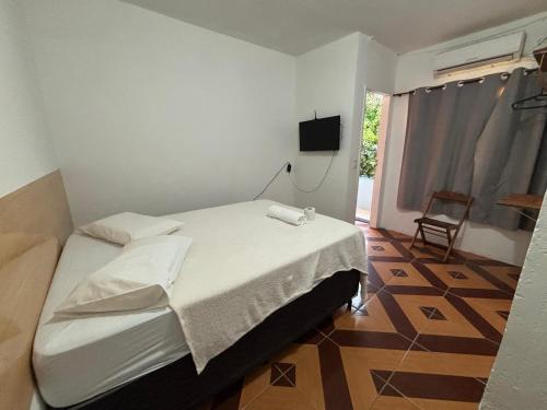 a bedroom with a bed and a tv on the wall at Prédio AZUL in Itacaré