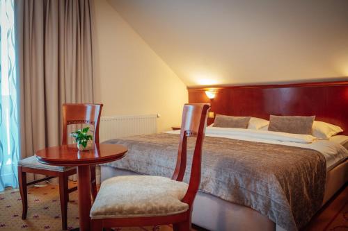 a hotel room with two beds and a table and chairs at Kala B&B in Kranjska Gora