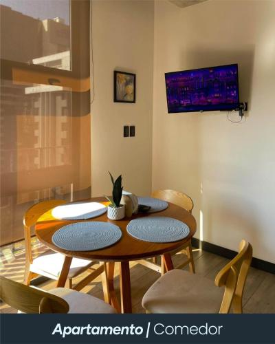 a dining room table with chairs and a tv on the wall at Eon 5 - Apartamento en edificio de lujo - Zona 10 de la Ciudad de Guatemala in Estación Pamplona