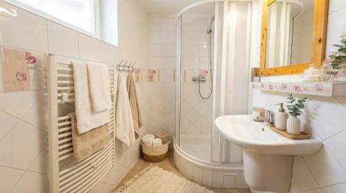 a white bathroom with a sink and a shower at Apartmán 339 - Tatralandia in Liptovský Mikuláš