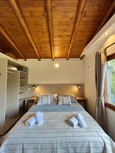 a bedroom with a large bed with a wooden ceiling at Luminosa Patagónia in Lago Puelo