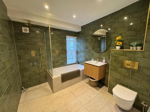 a bathroom with a shower and a toilet and a sink at Harbour Retreat Cottage 3 bedroom in Poole