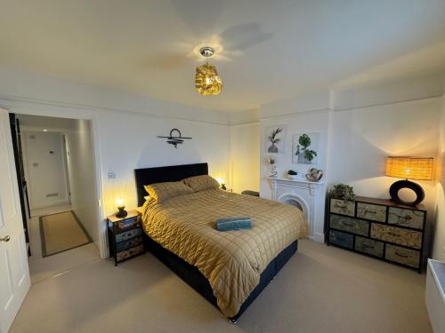 a bedroom with a large bed and a bathroom at Harbour Retreat Cottage 3 bedroom in Poole