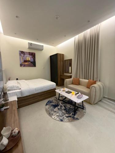 a bedroom with a bed and a couch and a table at Nafel Modern Suite in Riyadh