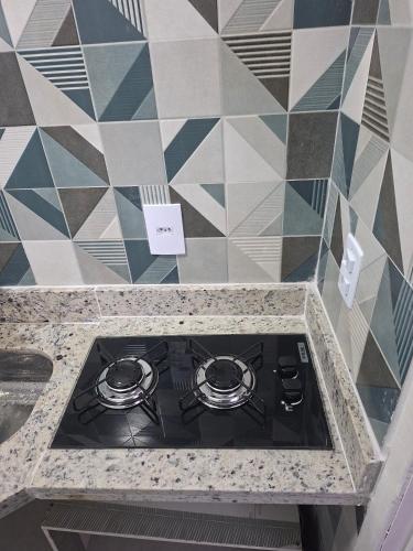 a stove top in a kitchen with a tile wall at Apartamento Brisa do Mar - Casas confortáveis para casal e acompanhantes com garagem in Búzios