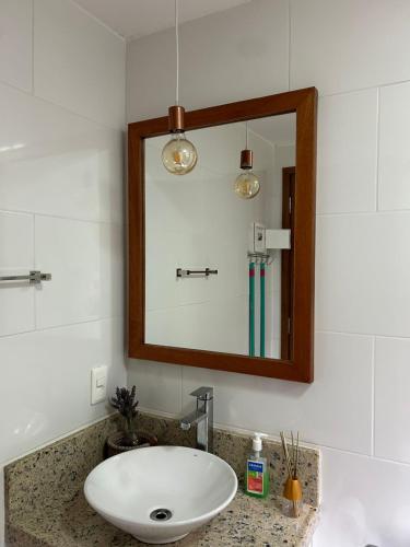 a bathroom with a sink and a mirror at Chalé do Riacho in Nova Friburgo