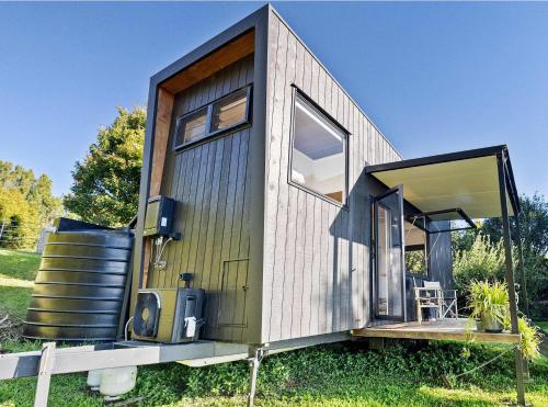 a tiny house with a large sliding glass door at Lily Pad Tiny Home in Maleny