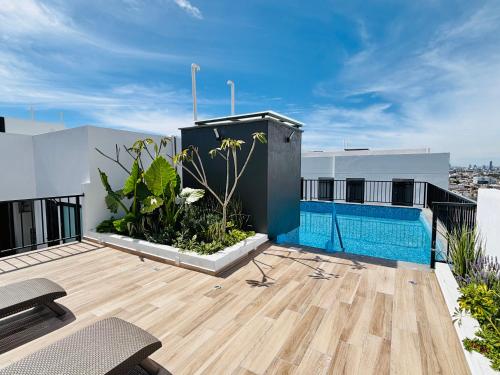 a rooftop deck with a swimming pool on a building at Depa Familiar con cochera 6 min Centro Médico y Catedral in Guadalajara
