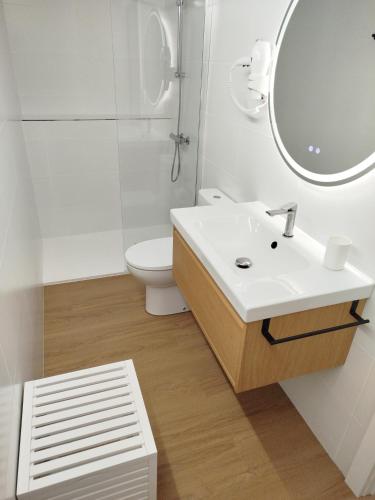 a bathroom with a sink and a toilet and a mirror at La de Simón in A Guarda