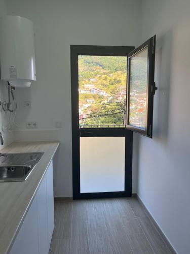 a kitchen with a window in the corner of a room at Cozy Noia in Machico
