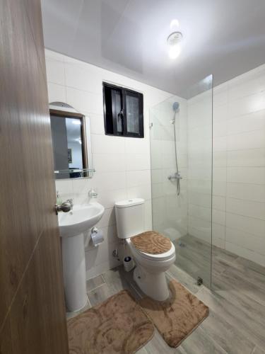 a bathroom with a toilet and a sink and a shower at Relaxing & New Retreat 3 bedroom riviera Verde in Santo Domingo