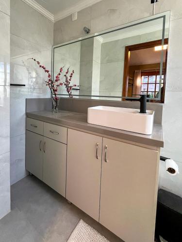 a bathroom with a sink and a mirror at Casa For Rua Torta in Gramado