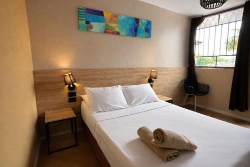 a bedroom with a bed with towels on it at Wild Rover Huacachina in Ica