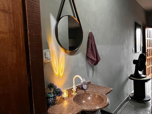 a bathroom with a sink and a mirror on the wall at Loft B - individual Mobiliado com Ar-condicionado in Dourados
