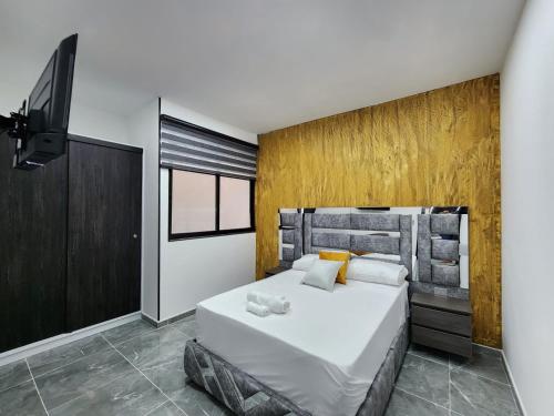 a bedroom with a large bed and a flat screen tv at Apartamentos Batara in Filandia
