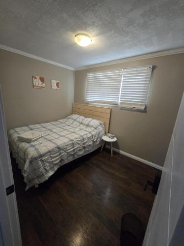 a small bedroom with a bed and a window at Like Home in Regina