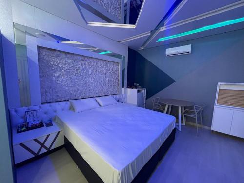 a bedroom with a bed in a room with blue lights at Motel Sedución (Adults only) in Cascavel