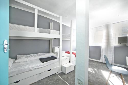 a bedroom with bunk beds with a desk and a chair at CBD City views on 61 wale street by M&B in Cape Town