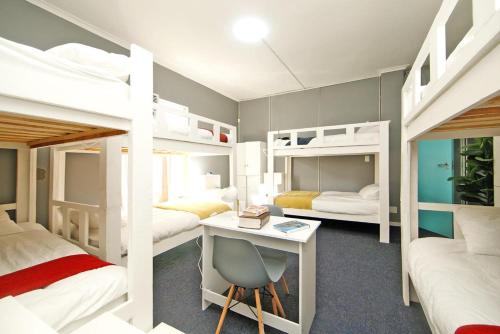 a dorm room with bunk beds with a desk and a desk at CBD City views on 61 wale street by M&B in Cape Town