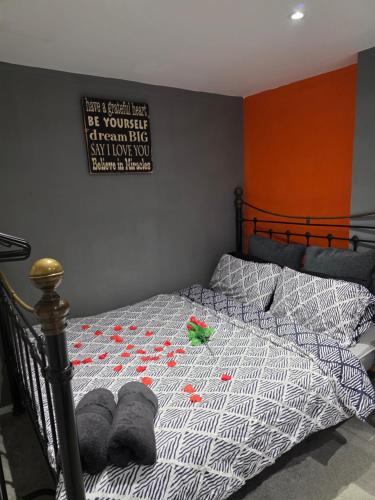a bed with red flowers on it in a bedroom at Cozy Garden Apt - 8ight Havens in Folkestone