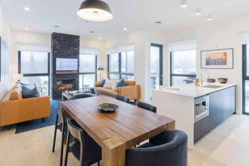 a kitchen and living room with a wooden table and chairs at The View - Luxury Penthouse Condo in Revelstoke