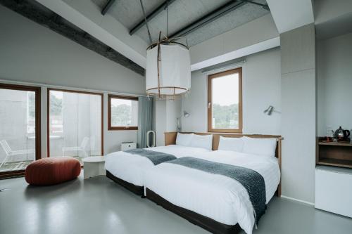a bedroom with a large white bed and windows at KOTOBUKI Hotel in Kanoya