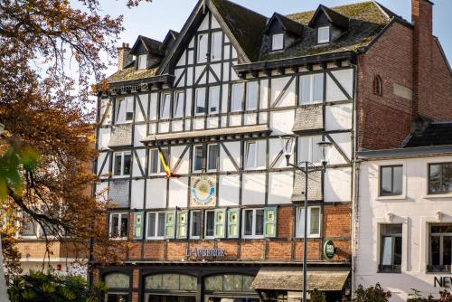 a large white building with a clock on it at Hôtel-Restaurant L'Auberge in Spa