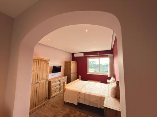 a bedroom with a bed and a window at Panoramic View Penthouse With Dual Terraces in Xagħra