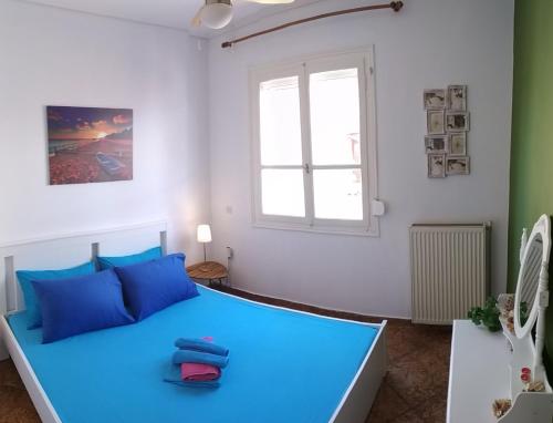 a bedroom with a blue bed and a window at P & G Apartment in Pámfylla