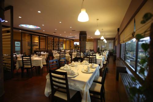 a restaurant with tables and chairs with white tablecloths at Hotel Continental in Vorë