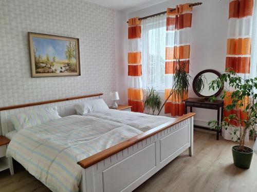 a bedroom with a large bed with orange and white curtains at Villa EDEN BLICK in Edenkoben