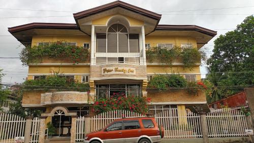 a small car parked in front of a house at Paper Country Inn in Mangagoy