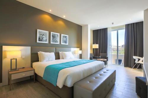 una camera d'albergo con un letto grande e un divano di Salini Resort a San Pawl il-Baħar